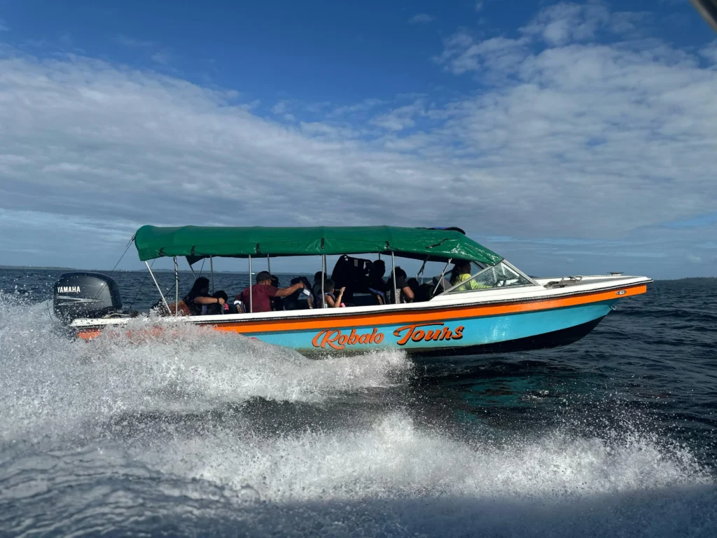 Lancha de Robalo Tours navegando por el mar Caribe con turistas disfrutando de una excursión en Bocas del Toro, Panamá